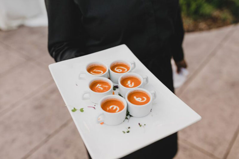 a man holding soup tray