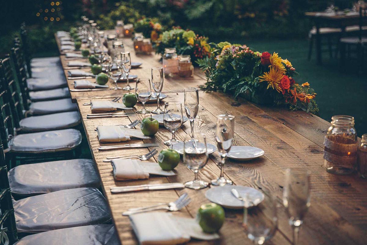 wedding party table with flowers, mason jars and apples
